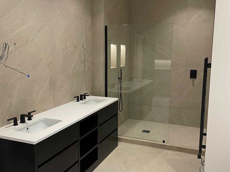 Bathroom fitted with a double vanity unit and a glass walk-in shower