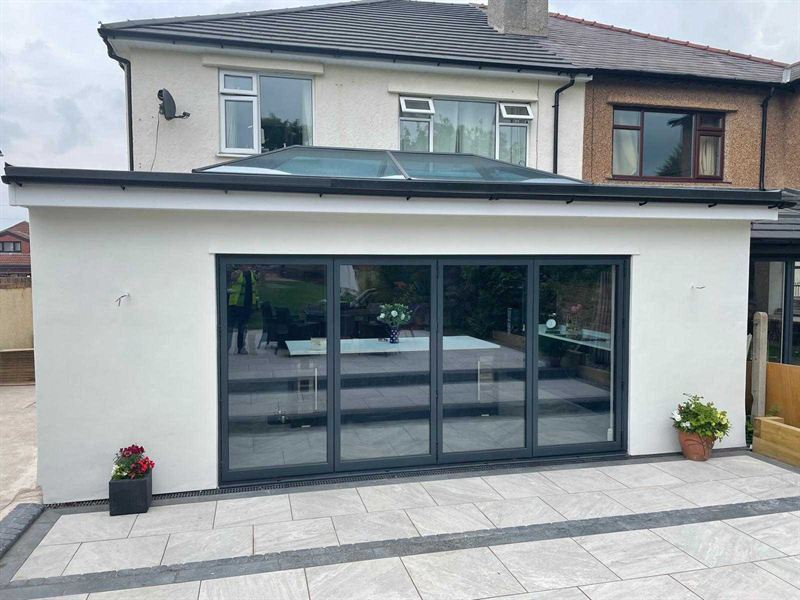 Single storey rear extension with anthracite bi-fold doors opening onto a porcelain patio