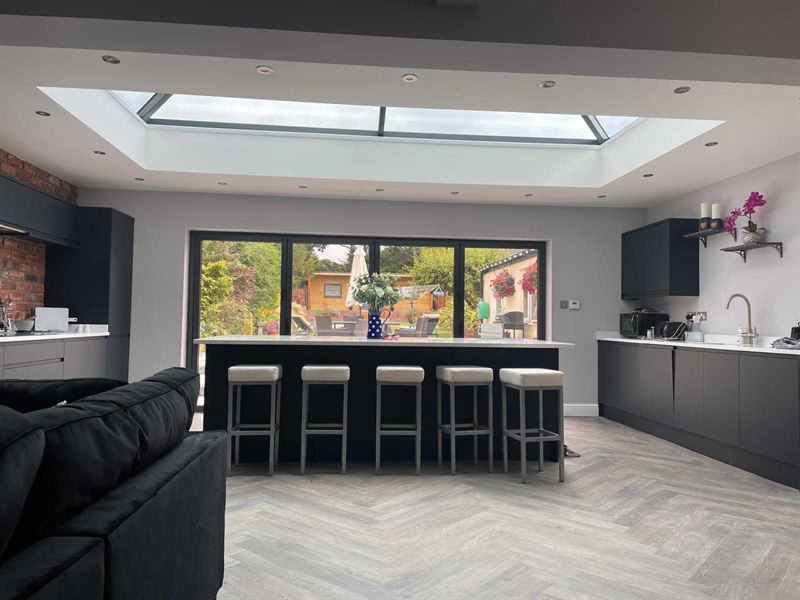 Kitchen extension with a breakfast island, herringbone flooring and a roof lantern above