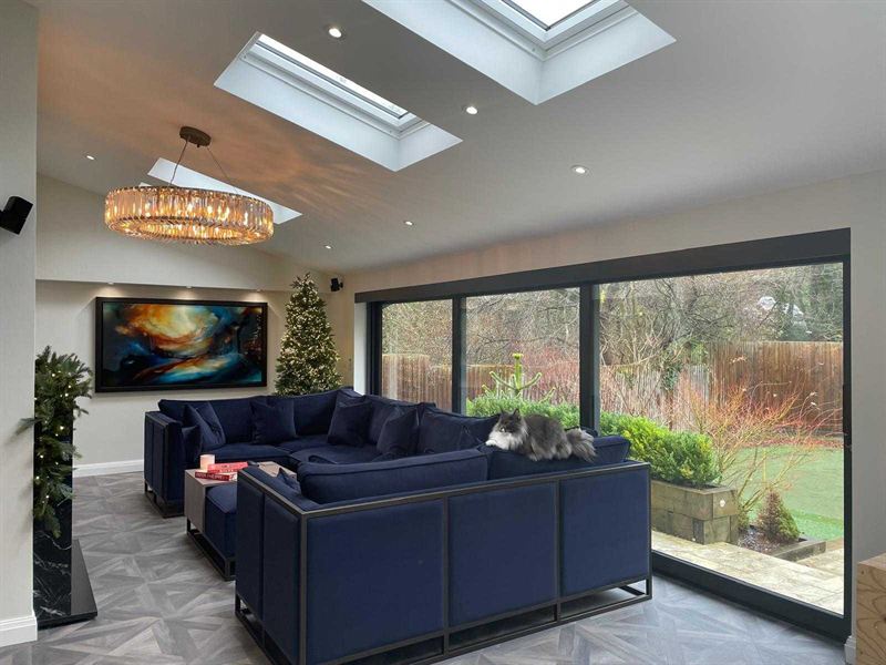 Open plan lounge in a rear extension lit by two large rooflights, with sliding doors to the garden