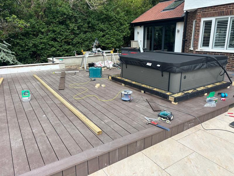 Composite decking being built out around a hot tub, with the frame and fixings still in progress