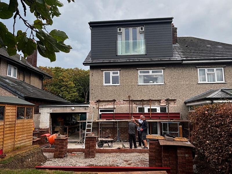 Completed rear dormer above ground floor works in progress, with bricklayers on site