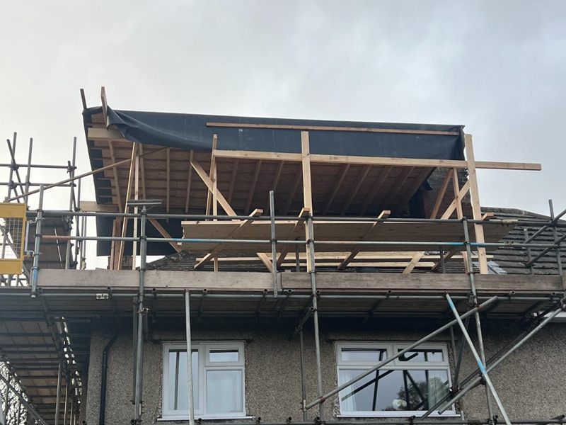 Timber frame of a new dormer taking shape on a loft conversion, sheeted over against the weather