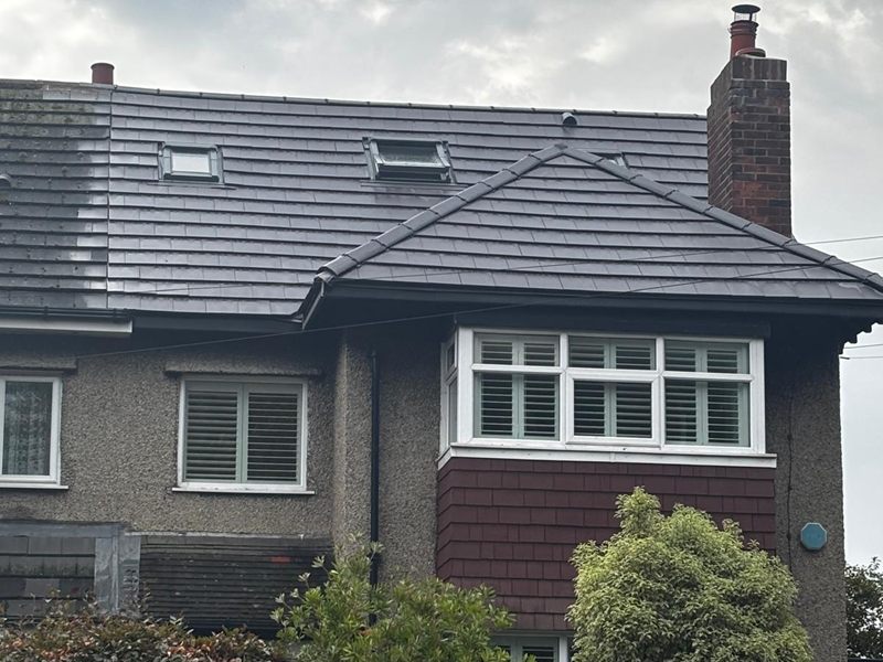 Newly tiled roof with rooflights above a pebbledash semi detached house