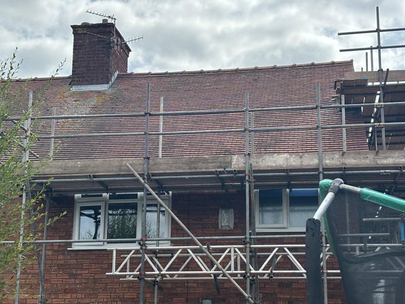 Original clay tiled roof and scaffolding to the rear of a house before its loft conversion begins
