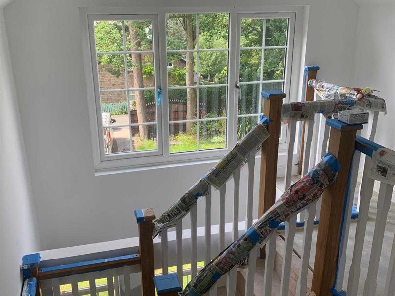 New oak and glass staircase leading up to a completed loft conversion