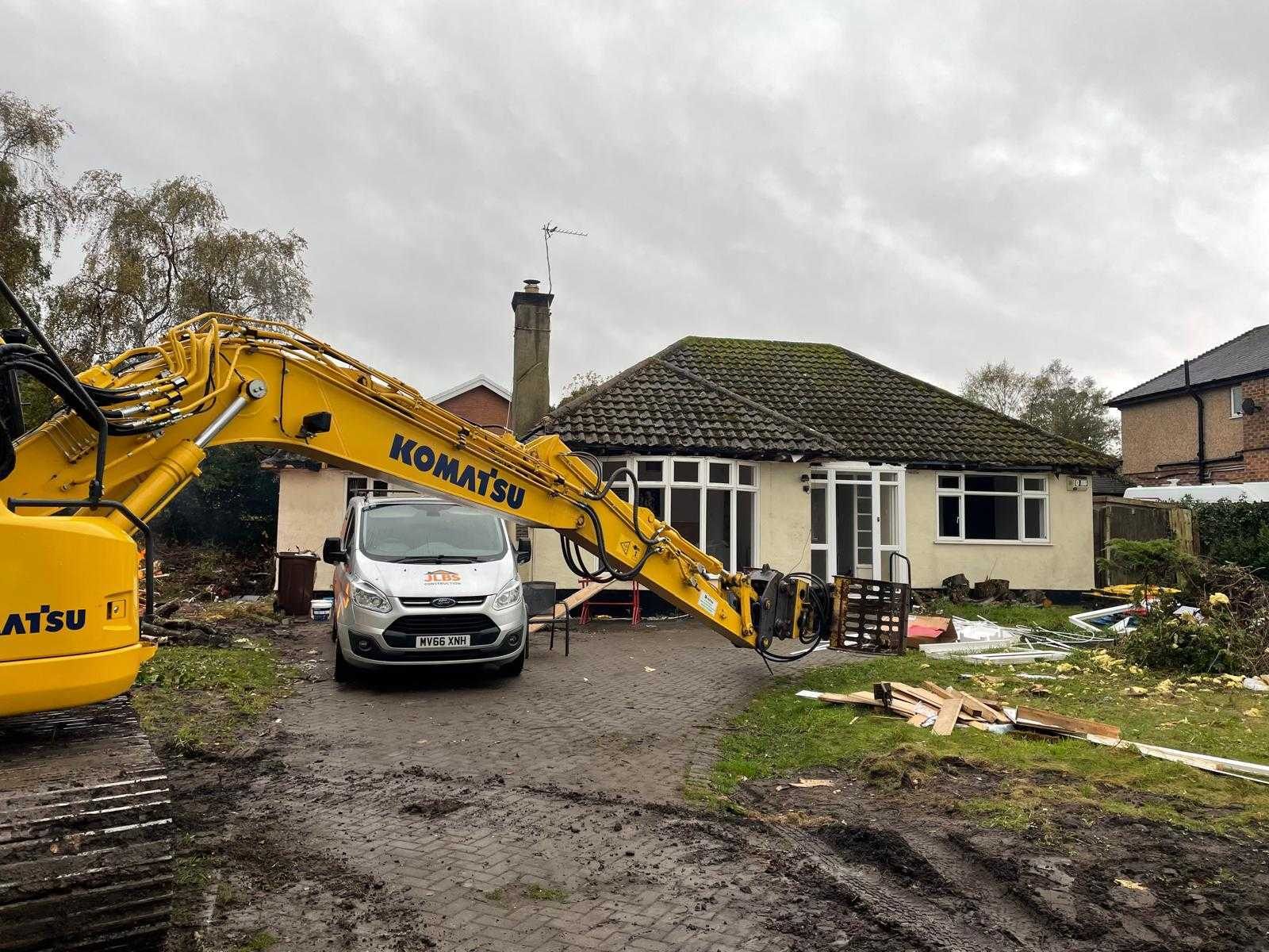 The original bungalow before demolition, with a JLBS Construction van and a tracked excavator on site